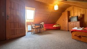a room with a door and a table and a bed at Endorfina in Muszyna