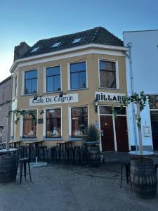 un bâtiment avec un café de cochin dans la rue dans l'établissement Borrel & Bed Onder zeil, à Zwolle
