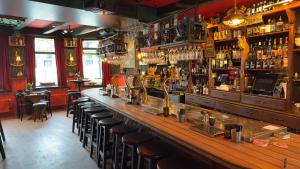a bar with a row of stools in a pub at Borrel & Bed Onder zeil in Zwolle