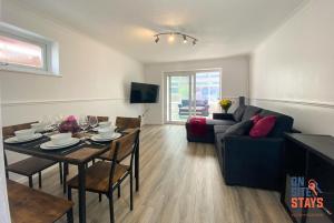 ein Wohnzimmer mit einem Tisch und einem Sofa in der Unterkunft OnSiteStays - Ideal Long Term Retreat, 2-BR House with Conservatory, Parking & Wi-Fi in Canterbury