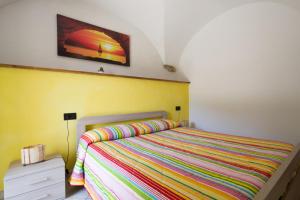 um quarto com uma cama com uma colcha colorida listrada em Agriturismo del Ponte "pomelo" em Rialto
