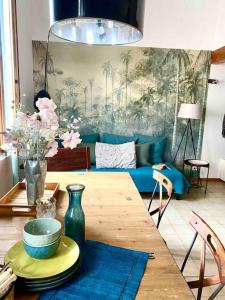 Una sala de estar con una mesa y un sofá azul. en Duplex Arago au coeur de Sète, comme une petite maison, en Sète