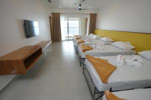 a row of beds lined up in a room at Misty Queen By Dimora Hotels in Kakkadampoyil