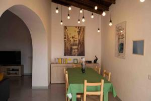 een eetkamer met een groene tafel en stoelen bij Volver in Salerno