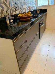 a kitchen with a sink and a bowl of fruit at Canto do Aconchego Praia de Itaparica in Vila Velha