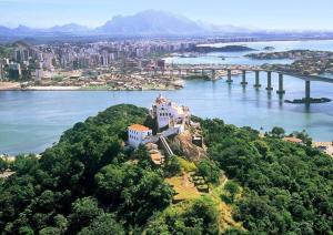 a house on top of a hill next to a body of water at Canto do Aconchego Praia de Itaparica in Vila Velha