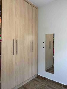 a room with two wooden cabinets and a mirror at Canto do Aconchego Praia de Itaparica in Vila Velha