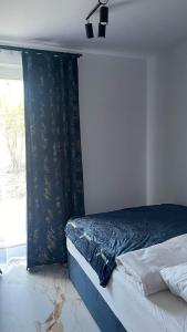 - une chambre avec un lit doté d'un rideau noir et d'une fenêtre dans l'établissement Apartament Niebieski 14/1, à Starogard Gdański