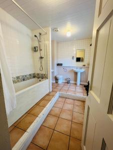 uma casa de banho com uma banheira, um WC e um lavatório. em Peak Hotel Castleton em Castleton