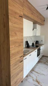 - une cuisine avec des placards blancs et un mur en bois dans l'établissement Apartament Niebieski 14/1, à Starogard Gdański