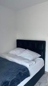 a bed with white sheets and a black headboard at Apartament Niebieski 14/1 in Starogard Gdański +4 photos