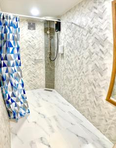 a bathroom with a shower with blue and white tiles at Glamping hill khaoyai in Khao Yai