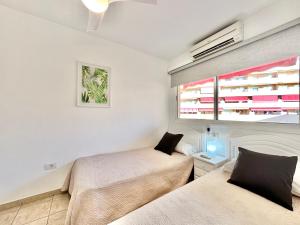 a bedroom with two beds and a window at Kpaco Apartment in Puerto de Santiago +43 photos