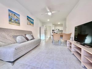 a living room with a couch and a flat screen tv at Kpaco Apartment in Puerto de Santiago