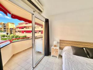 a bedroom with a balcony with a bed and a window at Kpaco Apartment in Puerto de Santiago