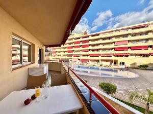 a balcony with a table and a swimming pool at Kpaco Apartment in Puerto de Santiago