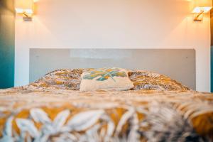 Bett mit einer Bettdecke und einem Kissen darauf in der Unterkunft Suite Lou _ Résidence Isaelle in Bray-Dunes