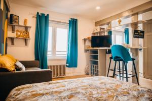 Schlafzimmer mit blauen Vorhängen, einem Bett und einem Schreibtisch in der Unterkunft Suite Lou _ Résidence Isaelle in Bray-Dunes
