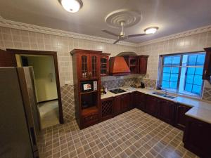 a large kitchen with wooden cabinets and a window at Ibranad Apartments in Accra