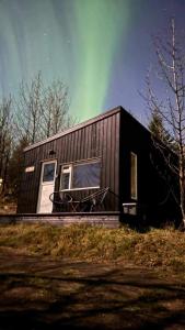 una casa negra con un cielo verde en Audkula Dome Cabin, en Hella