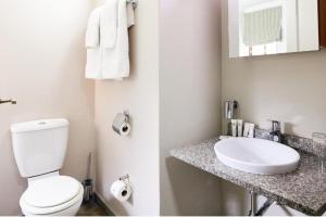 bagno con servizi igienici bianchi e lavandino di Unit H011 Magalies Park Hartbeespoort a Hartbeespoort