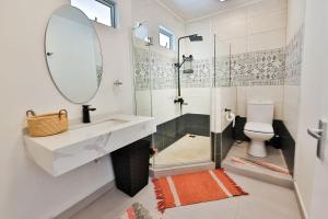 a bathroom with a shower and a sink and a mirror at OceanBreeze Apartments Mont Choisy in Mont Choisy