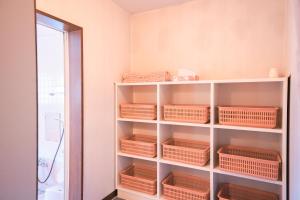 Zimmer mit Regalen mit Körben und Spiegel in der Unterkunft 豊島ロッヂooバス停浅貝上前 in Yuzawa