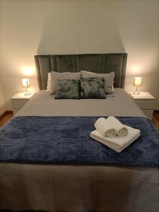 ein Bett mit zwei Handtüchern und zwei Ringen darauf in der Unterkunft CasaMaeDouro1 in Peso da Régua