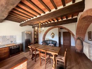 チッタ・デッラ・ピエーヴェにあるBorgo Siliano - Antico Podere Silianoのキッチン、ダイニングルーム(木製のテーブルと椅子付)