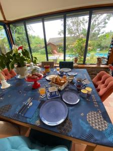 einen Tisch mit einem blauen Tischtuch mit Essen drauf in der Unterkunft CASA SORRISO in La Daguenière
