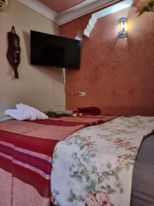 a bedroom with a bed with a tv on the wall at Casa del Sol Marrakech in Marrakech