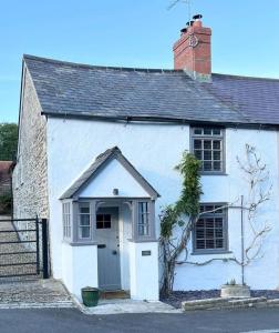 un edificio blanco con puerta y ventana en Cosy two bedrooom cottage set in a Dorset village en Sturminster Newton