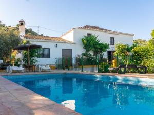 a villa with a swimming pool in front of a house at Casa Rural Huerta la Lapa in Cañete la Real