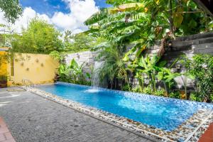 una piscina con una cascada junto a un edificio en Villa Hero 5 bed roooms near beach, luxury swimming pool, en Da Nang