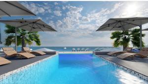 a swimming pool with chairs and umbrellas next to the ocean at ZEST THASSOS LUXURY RETREAT in Limenaria