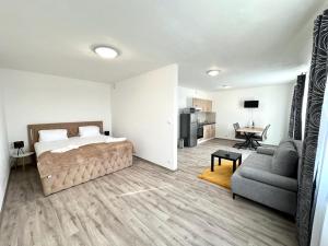 a bedroom with a bed and a couch and a table at Sky apartments 504 in Plzeň