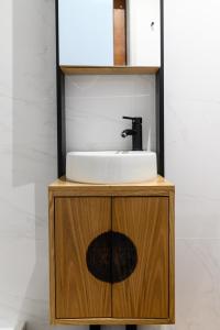 a bathroom sink on top of a wooden cabinet at Maria da SÉ Historic House in Porto
