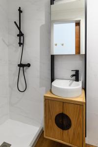 een badkamer met een wastafel, een spiegel en een douche bij Maria da SÉ Historic House in Porto
