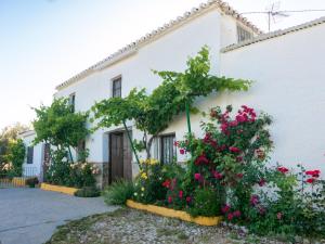 una casa blanca con flores delante en Casa Rural Huerta la Lapa, en Cañete la Real