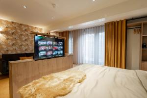a bedroom with a bed and a flat screen tv at Boetiekhotel Faan in Ballum
