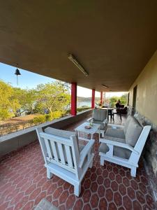 twee witte stoelen en een tafel op een patio bij Casa Corral Terra in Coronel Moldes