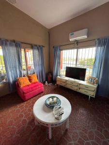 een woonkamer met een rode bank en een tafel bij Casa Corral Terra in Coronel Moldes