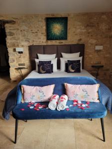 Una cama con un sofá azul con zapatos. en Chambre d'hôte avec SPA privatif domaine les nuits envôutées - Gard, en Vézénobres