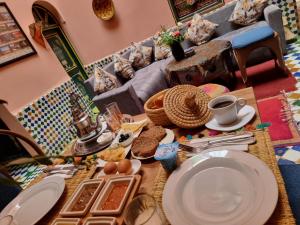 stół z talerzami i jedzeniem na górze w obiekcie Casa del Sol Marrakech w Marakeszu
