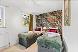 twee bedden in een kamer met muurschildering bij Beautiful House in Cambridge - Sleeps 6 in Milton