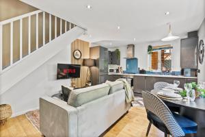 een woonkamer en een keuken met een bank en een tafel bij Beautiful House in Cambridge - Sleeps 6 in Milton
