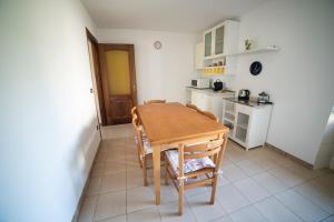 una pequeña cocina con mesa de madera y sillas en Cascina Pirondini, en San Cassiano
