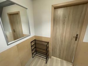 ein Badezimmer mit einem Spiegel und einer Holztür in der Unterkunft One More Night Apartment, Poznan Old Town in Posen