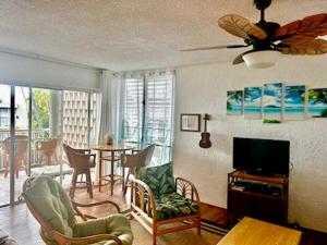 a living room with a ceiling fan and a television at Alii Villas 340 in Kailua-Kona