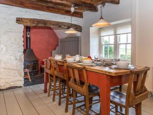 a large dining room with a long table and a fireplace at Wdig Cottage - Qc1264 in St. Davids